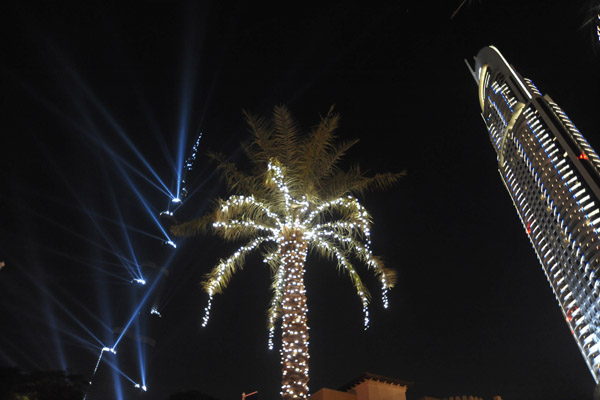 An illuminated palm centered between Burj Khalifa and the Address