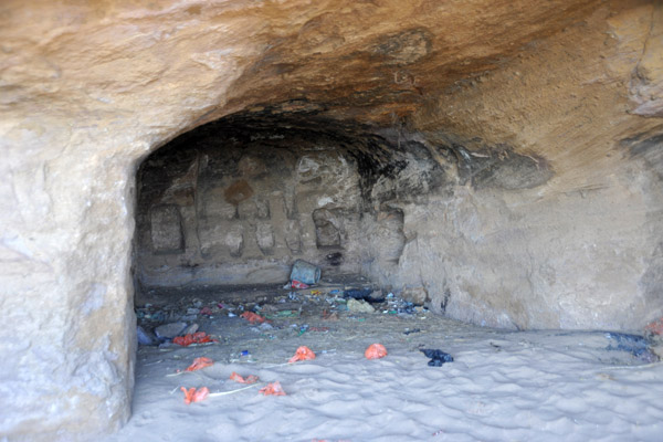 Ancient cave with the black soot of ancient cooking fires and the plastic trash of modern man