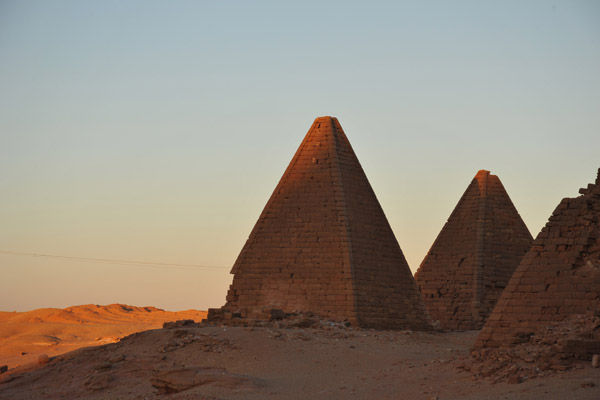 Sunlight strikes the tops of the first two pyramids