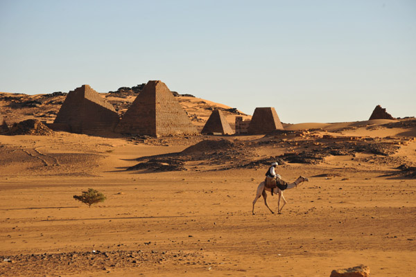 Man on a camel passing in front of the Southern Cemetery, Mero