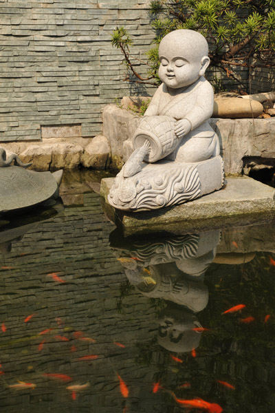 Sculpture of a monk releasing a carp into the pond