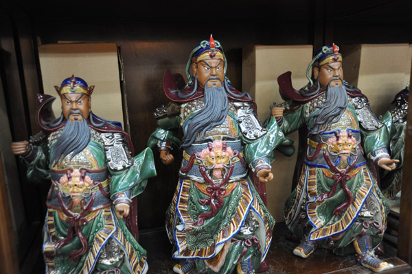 Statues of Emperor Guan Yu at a shop next to the temple