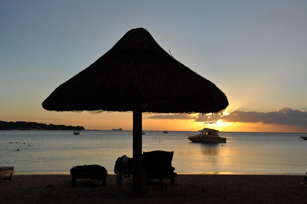 Mauritius sunset with the silhouette of a thatched beach umbrella, La Plantation