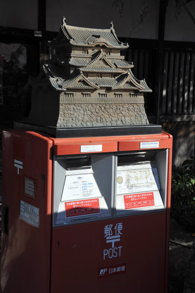 Japanese postbox with a bronze sculpture of the keep of Hikone Castle