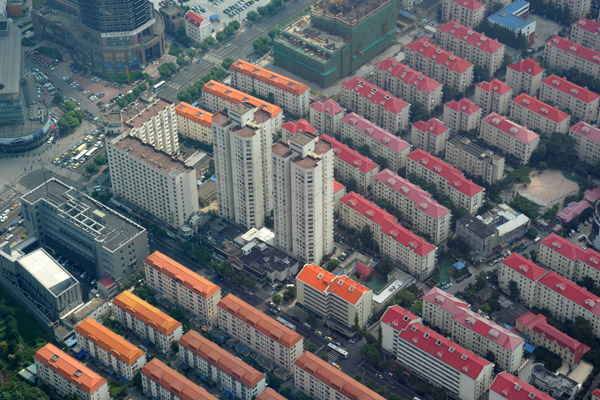 Red and orange roofs of mostly low-rise apartment blocks in the Pudong New Area, Shanghai