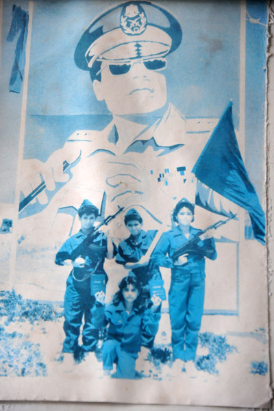 Old photo of armed kids in military uniform with Gadhafi's Green Book