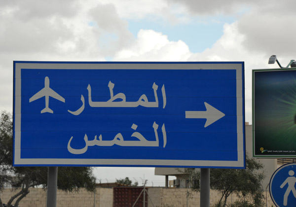 Libyan road sign for Tripoli Airport and Al Khoms, the modern city next to the ruins of Leptis Magna