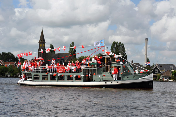 IJVeer XIII carrying the group Het Amazing Koor on the River Zaan past Zaanse Schans