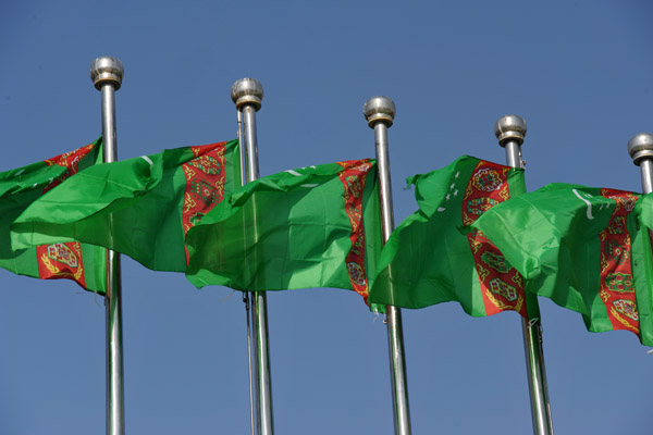 Turkmenistan flags against the blue sky at the Independence Monument