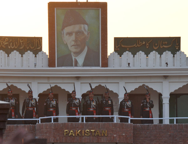 Pakistani Rangers line the balcony of the Gate of Pakistan below the portrait of Jinnah
