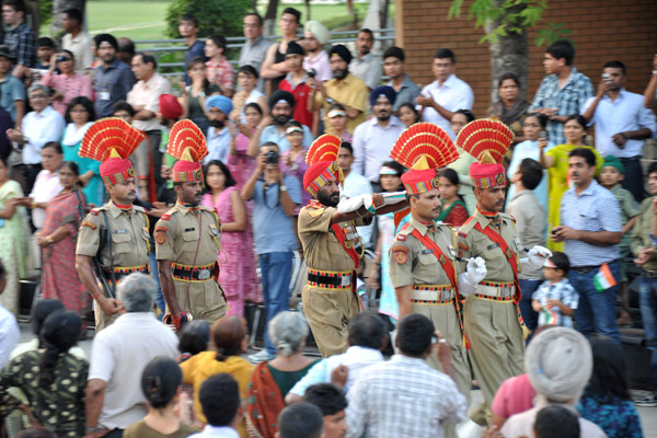 The BSF officer carries the flag of India back to the barracks with arms extended