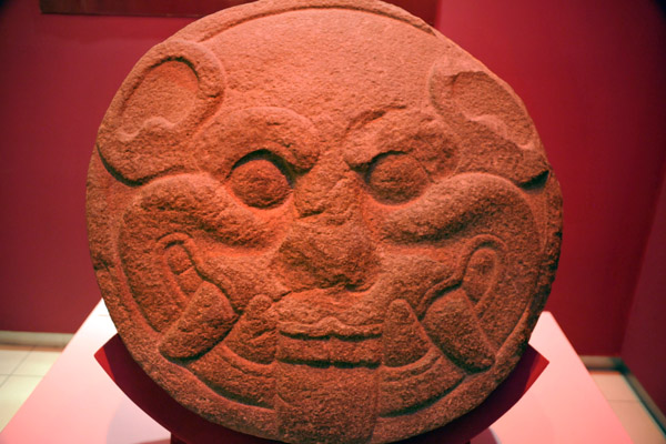 Stone disk found at Cara Sucia with the shape of a jaguar head, associated with the sun, from the Cotzumalhuapa culture