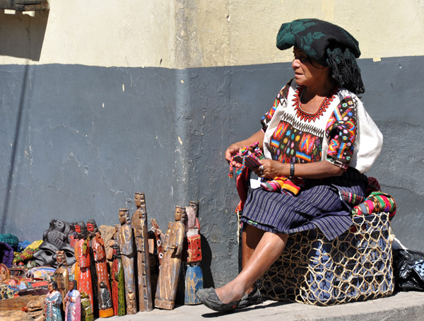 Woman selling wood carvings in front of the Maya Inn