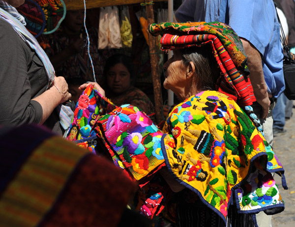 Old woman peddling textiles to a passing gringo