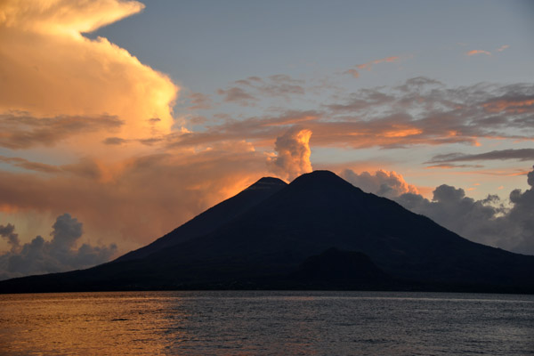 Clouds behind the twin volcanoes give the illusion of an eruption