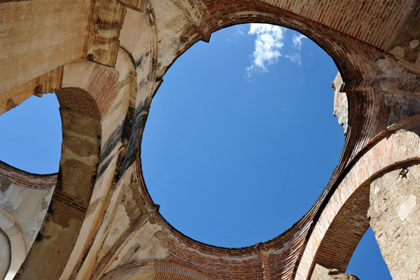 Looking up through an elliptical opening at blue sky