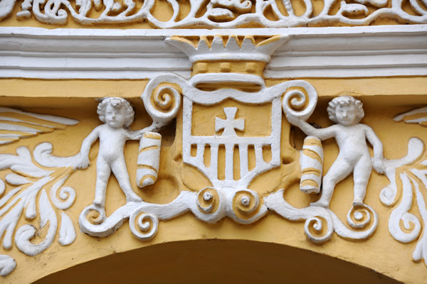 A pair of baroque cherubs holding a shield over the door of Nuestra Seora de la Merced