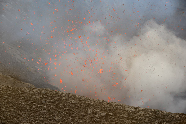 Daytime photos of Mount Yasur show the individual lava bombs shot up by the volcano