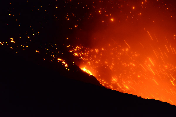 Lava bombs glow on the crater walls until they cool