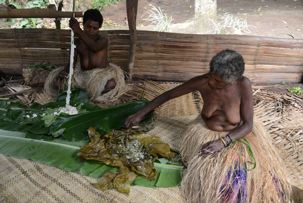 One of the older women of the Yakel tribe preparing traditional food