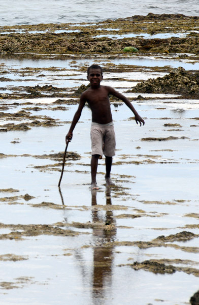 Boy crossing the sharp rocks barefoot