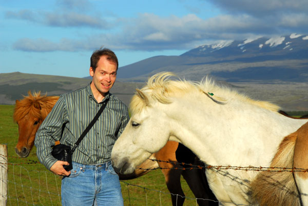 Roy greeting an Icelandic horse with Mount Hekla in the back