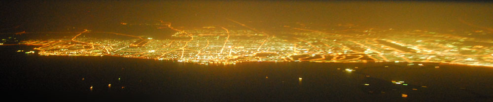 Night panorama of the UAE coast from Ajman to Deira centered on Sharjah