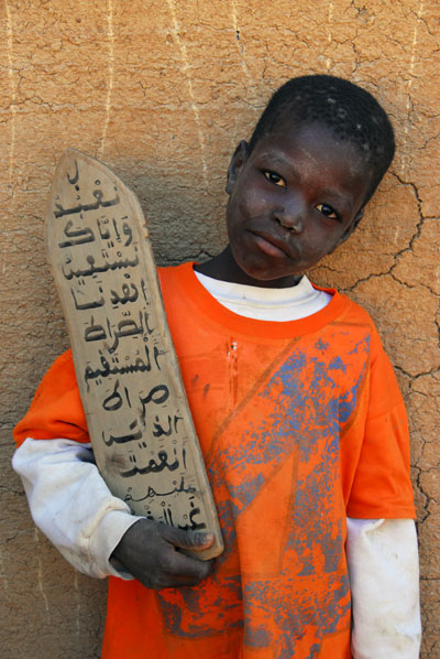 Boy holding a sura tablet at the Koranic school, Djenné