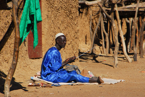 Man wearing silky blue listening to the radio, Ayorou