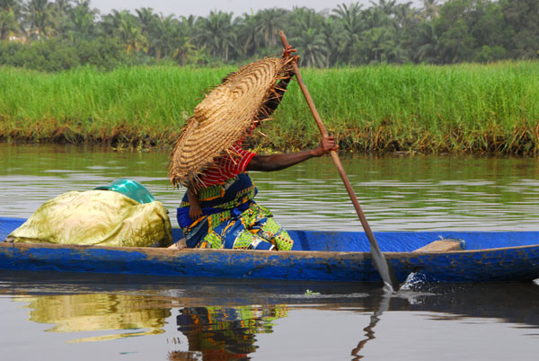 Ganvi woman in a big hat paddling a canoe