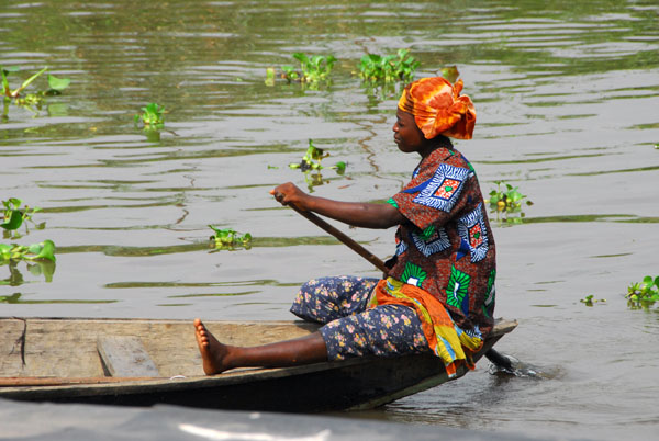 Woman paddling her canoe through the streets of Ganvié