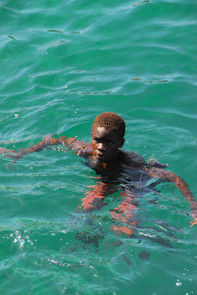 Boy swimming near the ferry