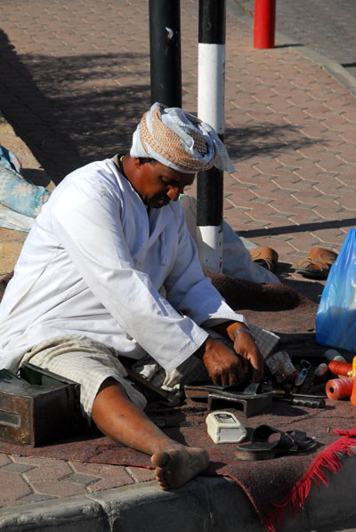 Omani street craftsman outside the souq gates