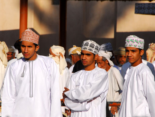 Young Omani men look on at the livestock souq