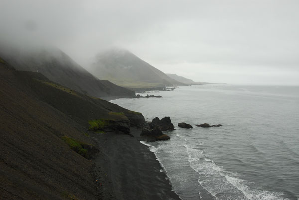 The unpaved section of road climbs high above coves with black sand beaches