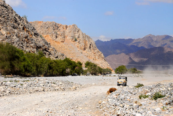 Another jeep approaches along the dusty wadi