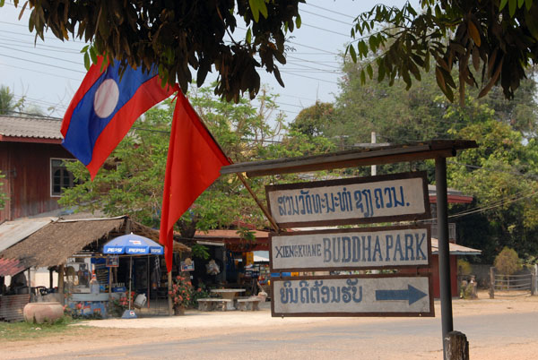Lao national and party flags at the entrace to Buddha Park