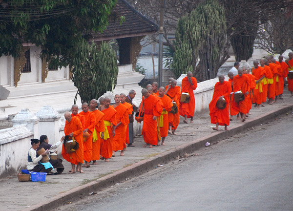 People with alms to give wait kneeling along the path