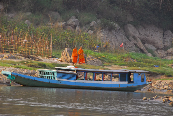 Monks along the Mekong with a boat