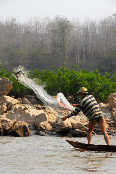 Lao fisherman casting his net