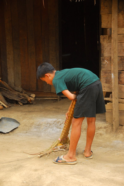 Mong boy sweeping the village