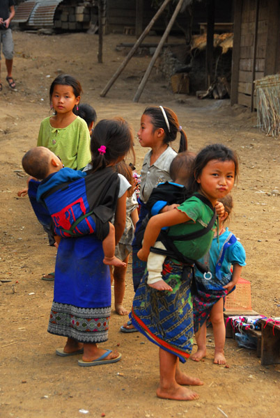 Young Mong girls carrying their baby siblings