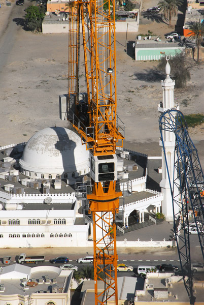 Construction crane on a Sheikh Zayed Road tower with a mosque