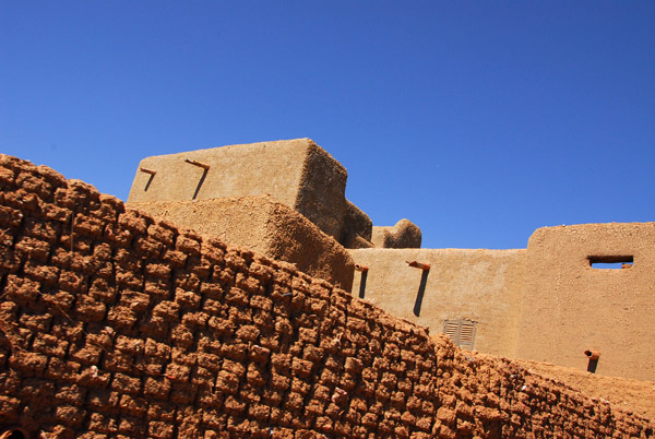 Mud-brick wall and a multi-story building, Djenné