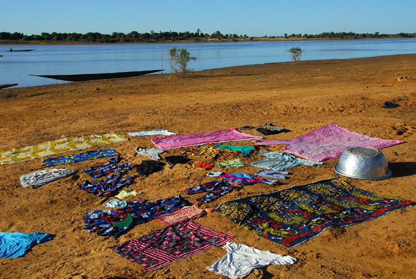 Clean laundry set out to dry in the dirt along the Bani River, Mali