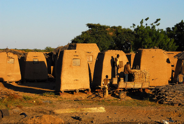Men loading millet into a granary, Mali