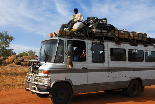 Man riding the roof with the luggage and the livestock, Dogon Country