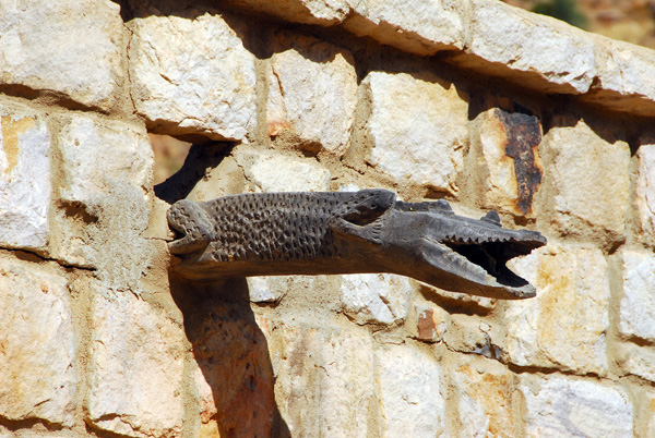 Crocodile shaped water spout out of a stone building in Tereli