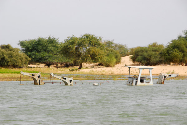 A boat sunk in the shallows of the Niger River
