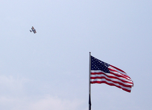 A biplane flying over the Wrights Brothers Memorial